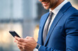 © OceanProd - businessman anonymous looking mobile phone close up shot of hand man using smartphone in suit