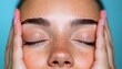 © TeteraX - Woman relaxing with closed eyes and hands on face against a blue background