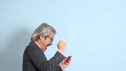 Wall Mural - The senior Asian man standing on the blue background.