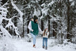 © alexkich - Young family for a walk. Mom and daughter are walking in a winter park.