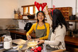 © Wavebreak Media - Christmas time, asian female teenager and grandmother wearing festive antlers, baking, at home