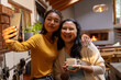 © Wavebreak Media - Taking selfie, Asian asian female teenager with grandmother holding coffee, smiling warmly at home
