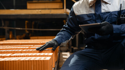 Wall Mural - Portrait man worker holding tablet computer for control quality of bricks. Production line of ceramics factory