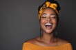 © Odin AI - A woman wearing a vibrant headwrap beams with a wide smile, exuding confidence and joy. The backdrop is dark, emphasizing her glowing, optimistic demeanor.