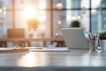 Poster - A modern office desk featuring a laptop and papers, bathed in warm sunlight streaming through a large window, creating a productive and serene atmosphere.