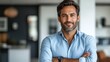 © IQ-Photography - charismatic indian handsome young businessman in smart casual attire confident pose with folded hands against clean white backdrop warm smile conveys approachability and professionalism modern corpora