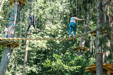 Wall Mural - experience a thrilling treetop adventure where participants navigate ropes, bridges, and daring chal