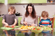 © sandsun - Happy family preparing healthy food in the kitchen, mother and children making wraps and cutting vegetables, teamwork, healthy eating, bright home atmosphere