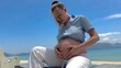 © Евгений Шемякин - Pregnant young woman is suffering from heat, sunstroke on the beach, sea. Dangerous sun
