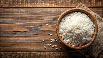 Poster - A bowl of cooked white rice on a wooden surface with a few grains scattered nearby
