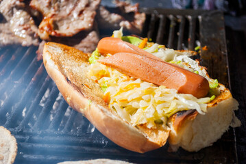 Street food in Guatemala, prepared on a charcoal grill, bread with sausages called 