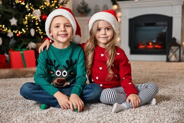 Wall Mural - Cute little kids with Santa hats in room decorated for Christmas