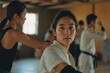 © I.J. Wheeler - Young Asian woman practicing martial arts in a dojo