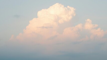Wall Mural - softly glowing cumulus clouds in a gradient of pastel colors against a pale blue sky, forming a wisp
