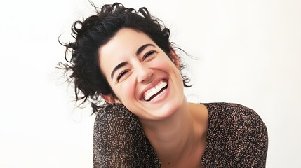 Wall Mural - Joyful woman with curly hair laughing against a light background.