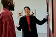 © AnnaStills - Art curator explaining contemporary art pieces to visitor while gesturing towards artwork on display. Artwork highlighted in clean gallery setting