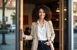 © Viktor - Smiling pro woman stands at business doorway. Daytime photo shows confident female in casual clothes, jacket. Stands outside modern office. Attractive businessperson welcomes clients. Exterior photo