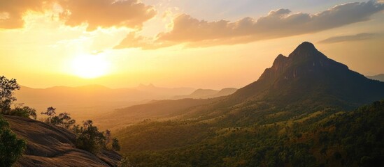 Poster - Mountain Range at Sunset with Golden Clouds and a Sunlit Valley
