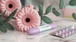 © lastfurianec - The photo shows a close-up of a pregnancy test, a package of birth control pills, a gerber daisy, green leaves and a marble surface. The image is intended to be a choice in a woman's life.