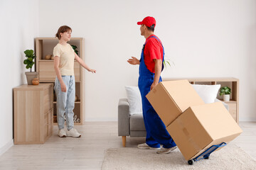 Wall Mural - Young woman receiving parcels from delivery man at home