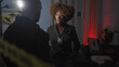 © Krakenimages.com - A woman detective with badge interrogates a man at a dimly-lit indoor crime scene with evidence and caution tape.