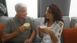 © Krakenimages.com - Middle-aged couple enjoying coffee together in a cozy living room, showcasing love and companionship in a homely indoor setting.