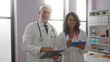 © Krakenimages.com - Doctors man and woman smiling and collaborating indoors at a hospital clinic, standing with stethoscope and tablet in a bright healthcare workplace.