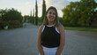 © Krakenimages.com - A young, beautiful hispanic woman stands outdoors in a serene villa setting in puglia, italy, with tall cypress trees and lush greenery in the background.