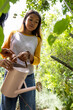 © Wavebreak Media - asian female teenager watering plants in garden with guidance, enjoying nature together