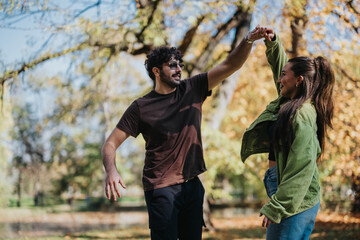 Wall Mural - A joyful young couple dances in an autumn park, surrounded by vibrant foliage. The scene captures a playful and romantic moment in nature.