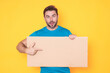 © Volodymyr - Handsome middle aged man with blank placard. Demonstrating copy space for your text or design. Man showing empty advertisement board on studio background. Blank placard, signboard for ad.