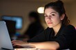 © vinod - focused young professional working on a laptop in a dimly lit environment