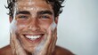 © JuliaDorian - Handsome Man with Blue Eyes Smiling while Washing his Face, Skin Care and Spa Concept.
