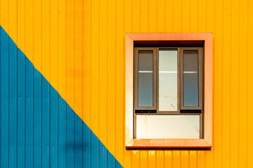 Window on a wall painted in blue and yellow