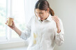 © KMPZZZ - Cloth stain, disappointment asian young woman clumsy with hot coffee, tea stains on shirt, hand show making spill drop on white t-shirt, spot dirty or smudge on clothes at home, isolated on background