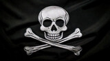 A high-resolution depiction of a classic Jolly Roger pirate flag, featuring a white skull and crossbones on a textured black fabric background. The flag appears slightly tattered and weathered, with d