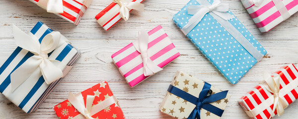 A lot of Christmas gift boxes in colored paper decorated on table, Top view close up. Many present New Year gift