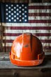 © olegganko - Hard hat placed on wooden surface with American flag as background in construction setting
