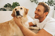 © Maria Vitkovska - Portrait of beautiful, happy, bearded man wearing casual clothes playing with dog, golden retriever