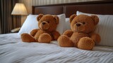 Two teddy bears sitting on a bed