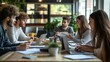 © mirifadapt - group of young entrepreneurs in a coworking space, discussing business ideas around a table