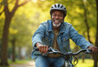 © PhotoPhantom - Happy mature senior black african american man riding his bicycle through a park on a sunny day