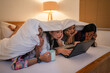 © Odua Images - A group of friends is enjoying a fun movie night together, all snuggled up under warm blankets