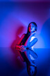 © FATIR29 - High Fashion model woman in colorful bright neon blue and purple lights posing in studio. Portrait of beautiful woman with trendy glowing make-up. Art design vivid style