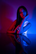 © FATIR29 - High Fashion model woman in colorful bright neon blue and purple lights posing in studio. Portrait of beautiful woman with trendy glowing make-up. Art design vivid style