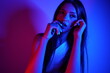 © FATIR29 - High Fashion model woman in colorful bright neon blue and purple lights posing in studio. Portrait of beautiful woman with trendy glowing make-up. Art design vivid style