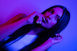 © FATIR29 - High Fashion model woman in colorful bright neon blue and purple lights posing in studio. Portrait of beautiful woman with trendy glowing make-up. Art design vivid style