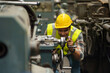 © iammotos - industrial Engineer indian man control lathe machine in industry manufacturing large factory . asian india labor worker male in hard hat and goggles working metal work in workplace . banner copy space