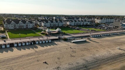 Wall Mural - Drone flying from over the sea towards the coastal houses of Long Branch at the golden hour