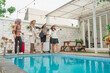 © Odua Images - A group of close friends joyfully celebrating together by the relaxing poolside, ready for vacation